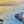 uitzicht vanaf baai met witte vakantiehuizen, palmbomen en paarse bloemen over zee tijdens zonsondergang tenerife spanje
